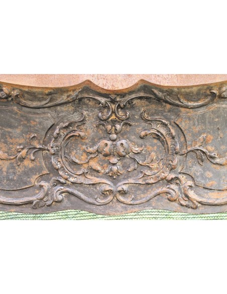 Large baroque cast iron insert, artistically crafted, that can be adapted to fit the mantel of a marble fireplace.
