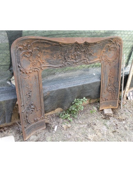 Large baroque cast iron insert, artistically crafted, that can be adapted to fit the mantel of a marble fireplace.