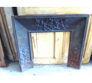 Antique cast iron insert, artistically crafted, designed to fit the opening of a marble fireplace mantel.