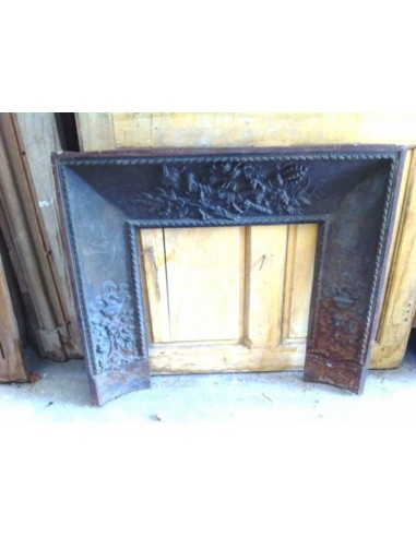 Antique cast iron insert, artistically crafted, designed to fit the opening of a marble fireplace mantel.