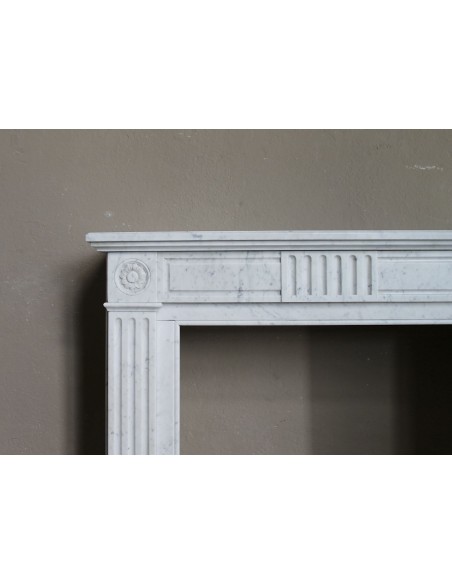 Charming Neoclassical antique fireplace in white marble, featuring refined floral sculptural details.