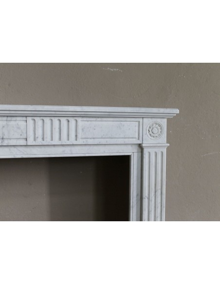 Charming Neoclassical antique fireplace in white marble, featuring refined floral sculptural details.