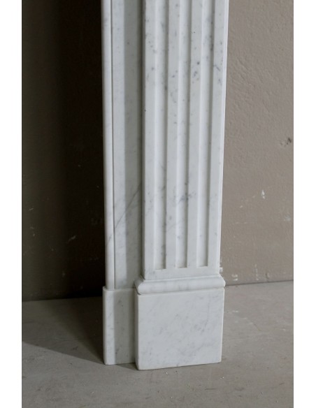 Charming Neoclassical antique fireplace in white marble, featuring refined floral sculptural details.