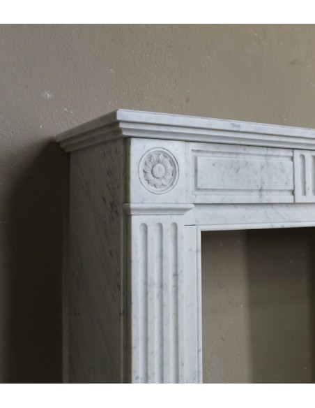 Charming Neoclassical antique fireplace in white marble, featuring refined floral sculptural details.