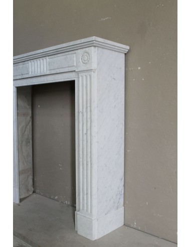 Charming Neoclassical antique fireplace in white marble, featuring refined floral sculptural details.