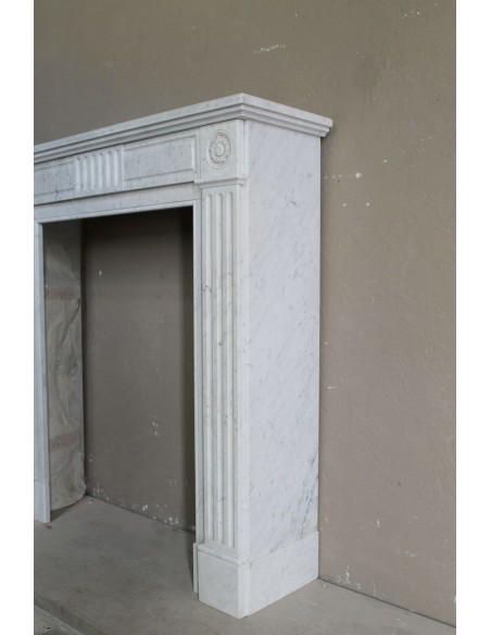 Charming Neoclassical antique fireplace in white marble, featuring refined floral sculptural details.