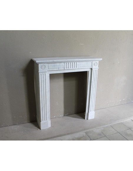 Charming Neoclassical antique fireplace in white marble, featuring refined floral sculptural details.