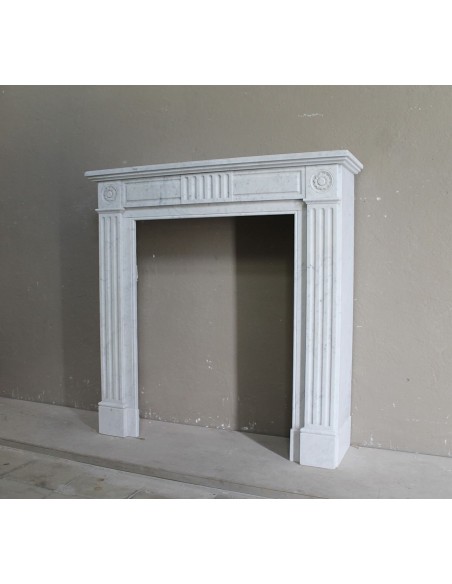 Charming Neoclassical antique fireplace in white marble, featuring refined floral sculptural details.