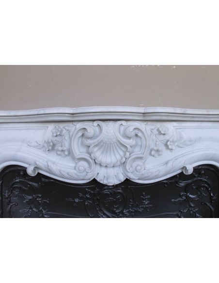 Exceptional antique Baroque fireplace mantel in white marble with floral carvings and its original cast iron insert.