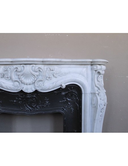 Exceptional antique Baroque fireplace mantel in white marble with floral carvings and its original cast iron insert.
