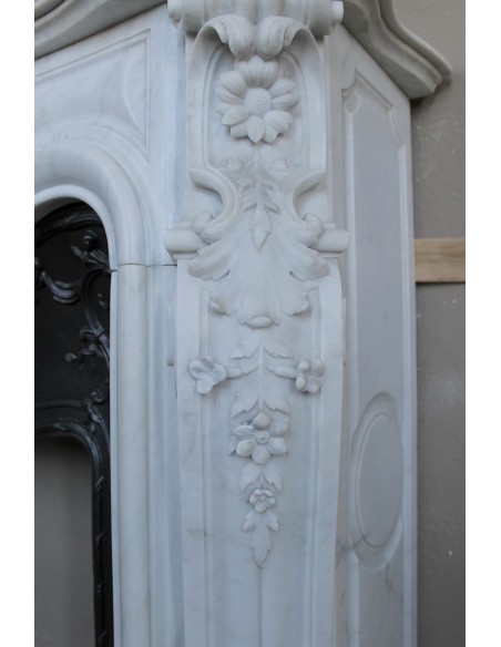 Exceptional antique Baroque fireplace mantel in white marble with floral carvings and its original cast iron insert.
