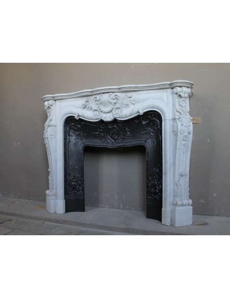 Exceptional antique Baroque fireplace mantel in white marble with floral carvings and its original cast iron insert.