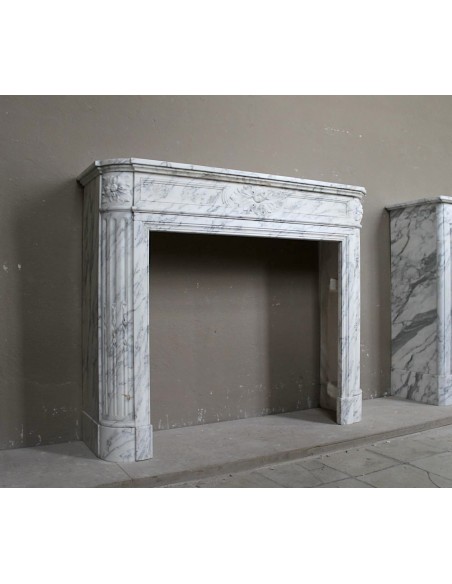 Neoclassical fire surround in Statuary Arabescato marble featuring soft gray veins on a white background.