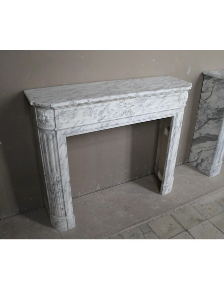 Neoclassical fire surround in Statuary Arabescato marble featuring soft gray veins on a white background.