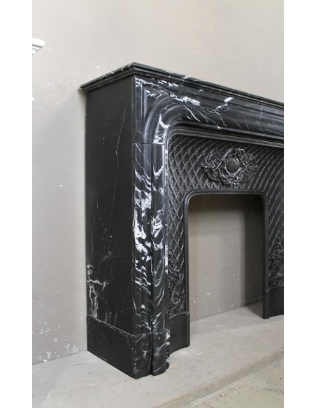 Antique "Boudin Arrondi" fireplace mantel in Black Marquinia veined marble provided with its original cast iron insert.