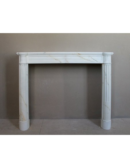 Antique neoclassical marble fireplace mantel with golden veins on a white background. A truly elegant marble fire surround.