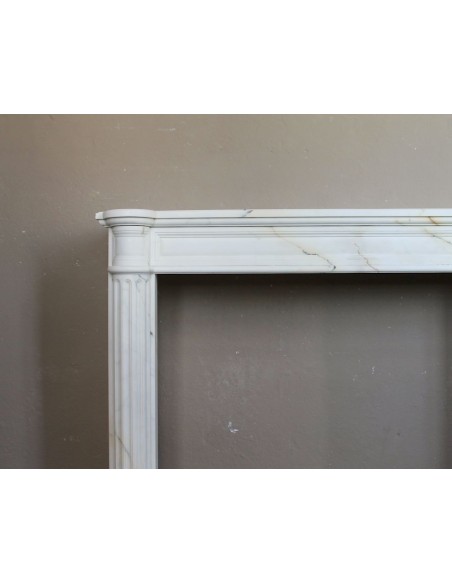 Antique neoclassical marble fireplace mantel with golden veins on a white background. A truly elegant marble fire surround.
