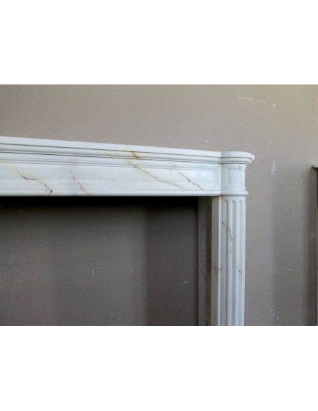 Antique neoclassical marble fireplace mantel with golden veins on a white background. A truly elegant white marble mantel