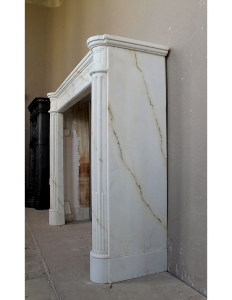 Antique neoclassical marble fireplace mantel with golden veins on a white background. A truly elegant marble fire surround.