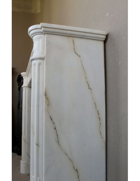 Antique neoclassical marble fireplace mantel with golden veins on a white background. A truly elegant marble fire surround.