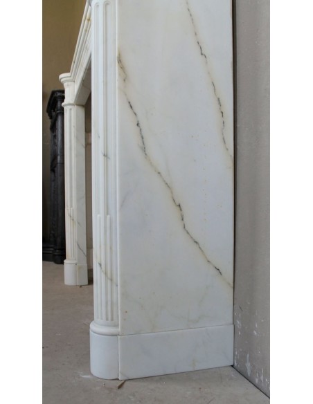 Antique neoclassical marble fireplace mantel with golden veins on a white background. A truly elegant marble fire surround.