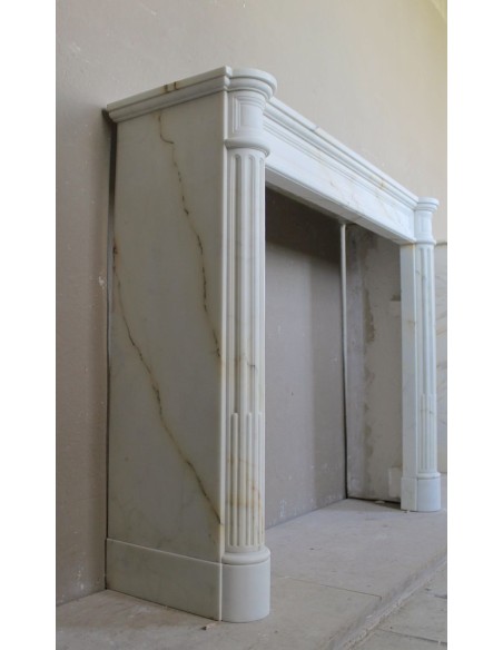 Antique neoclassical marble fireplace mantel with golden veins on a white background. A truly elegant white marble mantel
