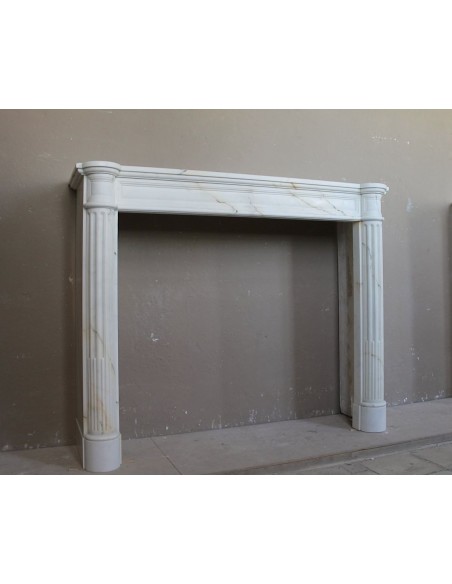 Antique neoclassical marble fireplace mantel with golden veins on a white background. A truly elegant white marble mantel