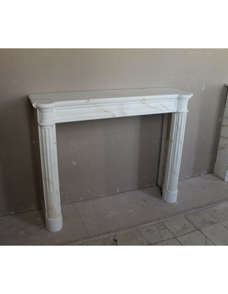 Antique neoclassical marble fireplace mantel with golden veins on a white background. A truly elegant white marble mantel
