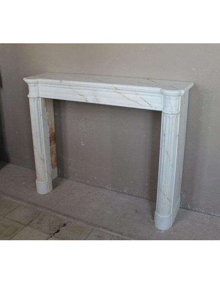 Antique neoclassical marble fireplace mantel with golden veins on a white background. A truly elegant white marble mantel