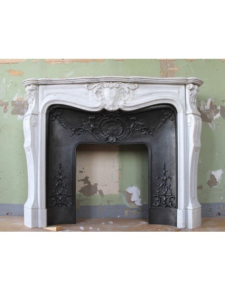 Louis XV “Moustache” fireplace mantel in White Carrara marble and fitted with its original cast iron insert.