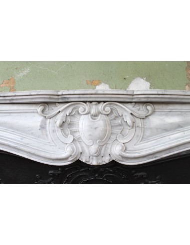 Louis XV “Moustache” fireplace mantel in White Carrara marble and fitted with its original cast iron insert.