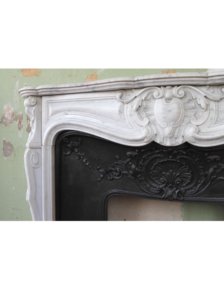 Louis XV “Moustache” fireplace mantel in White Carrara marble and fitted with its original cast iron insert.