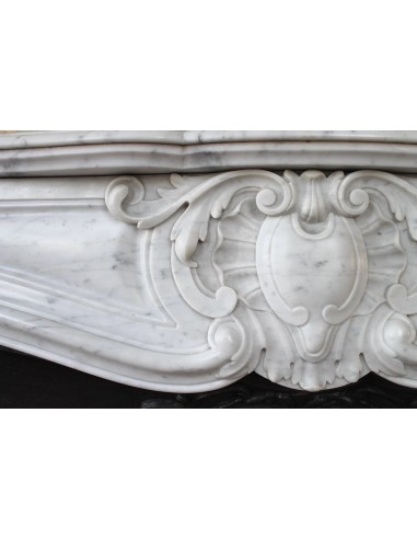 Louis XV “Moustache” fireplace mantel in White Carrara marble and fitted with its original cast iron insert.