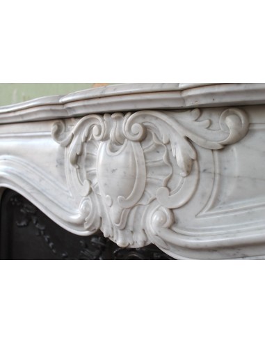 Louis XV “Moustache” fireplace mantel in White Carrara marble and fitted with its original cast iron insert.