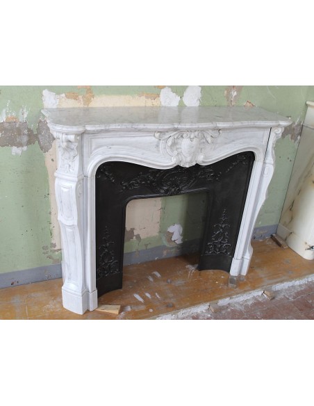 Louis XV “Moustache” fireplace mantel in White Carrara marble and fitted with its original cast iron insert.