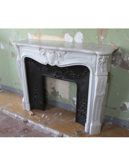 Louis XV “Moustache” fireplace mantel in White Carrara marble and fitted with its original cast iron insert.