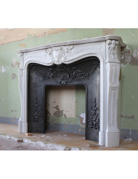 Louis XV “Moustache” fireplace mantel in White Carrara marble and fitted with its original cast iron insert.