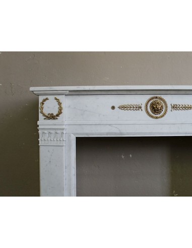 Antique neoclassical mantel carved in White marble with gilded bronzes depicting olive leaves and lions.