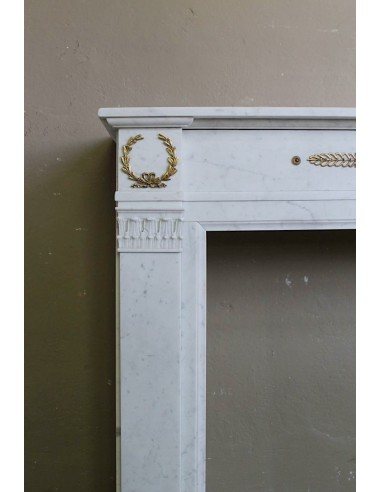 Antique neoclassical mantel carved in White marble with gilded bronzes depicting olive leaves and lions.