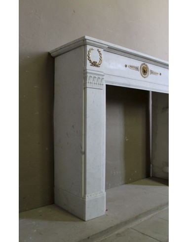 Antique neoclassical mantel carved in White marble with gilded bronzes depicting olive leaves and lions.