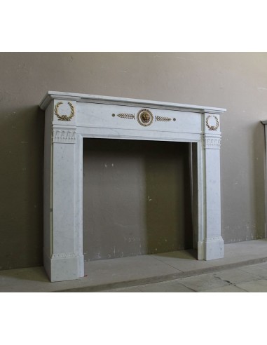 Antique neoclassical mantel carved in White marble with gilded bronzes depicting olive leaves and lions.