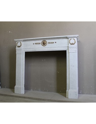 Antique neoclassical mantel carved in White marble with gilded bronzes depicting olive leaves and lions.