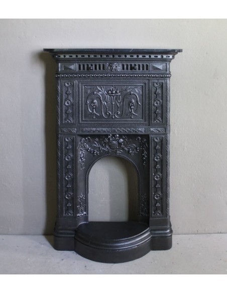 Antique “Larcher” cast iron mantelpiece with floral decorations. A refined, elegant, 19th-century antique fire surround.