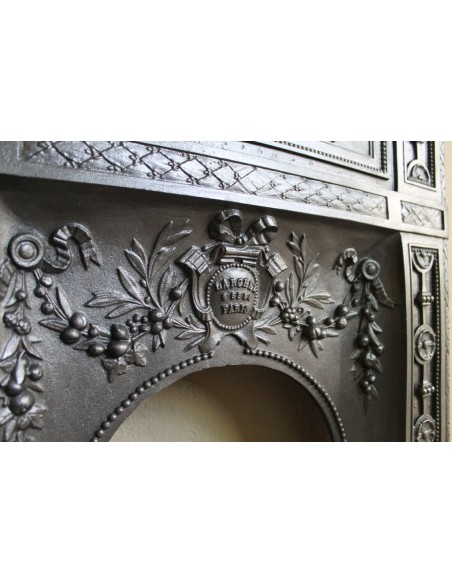Antique “Larcher” cast iron mantelpiece with floral decorations. A refined, elegant, 19th-century antique fire surround.