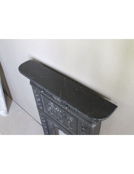 Antique “Larcher” cast iron mantelpiece with floral decorations. A refined, elegant, 19th-century antique fire surround.