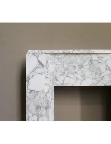 Antique iconic Art Deco mantelpiece carved in white veined Arabescato marble with Portoro marble inserts.