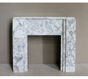 Antique iconic Art Deco mantelpiece carved in white veined Arabescato marble with Portoro marble inserts.