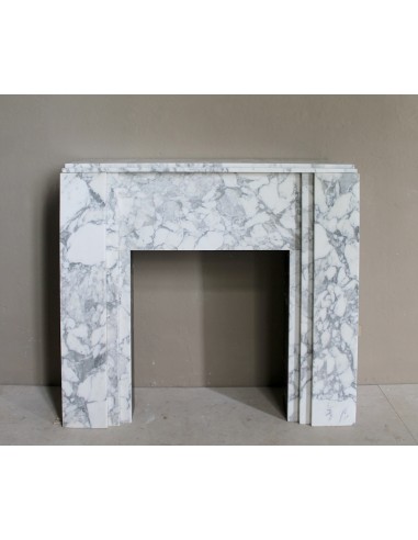 Antique iconic Art Deco mantelpiece carved in white veined Arabescato marble with Portoro marble inserts.