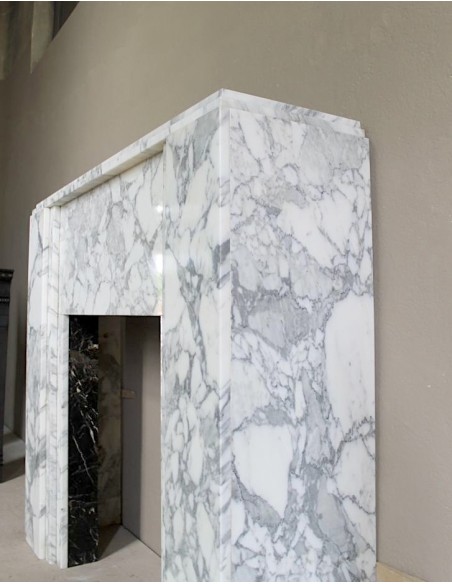 Antique iconic Art Deco mantelpiece carved in white veined Arabescato marble with Portoro marble inserts.