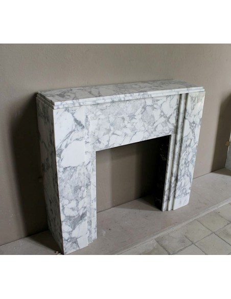 Antique iconic Art Deco mantelpiece carved in white veined Arabescato marble with Portoro marble inserts.